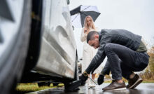 Young man helping beautiful woman to fix car on the road.